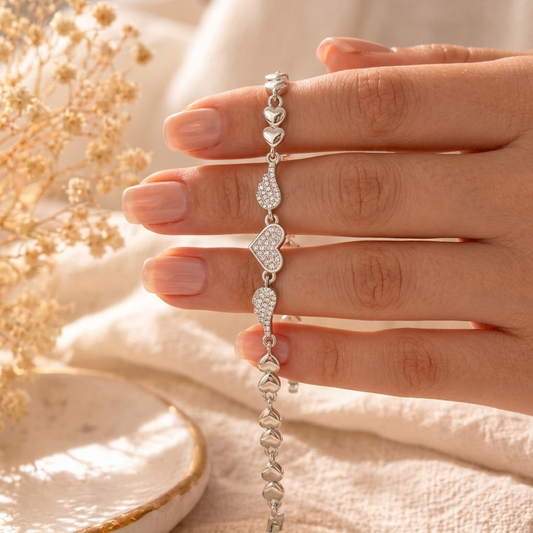 Silver Pave Angel Wing Heart Bracelet laid flat on cream linen with baby's breath