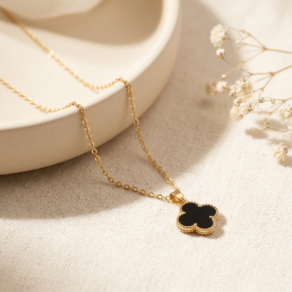 Black Clover Gold Necklace laid flat on cream ceramic tray