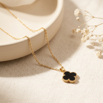 Black Clover Gold Necklace laid flat on cream ceramic tray