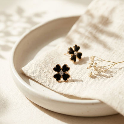 Black Clover Gold Stud Earrings held in hand showing milgrain border detail