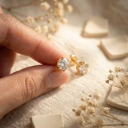 Gold Crystal Solitaire Stud Earrings on cream ceramic plate with dried pampas grass
