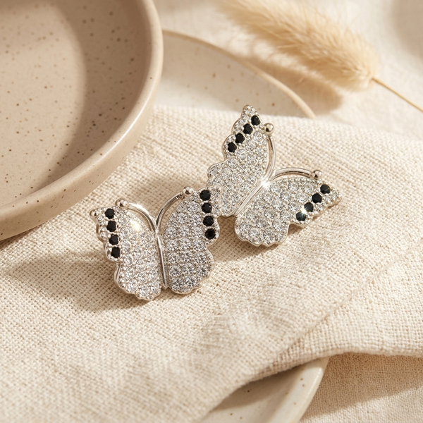 Silver Pave Butterfly Stud Earrings on wavy ceramic tray with baby's breath