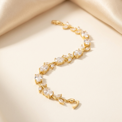 Gold White Stone Crystal Vine Leaf Bracelet laid flat on cream satin