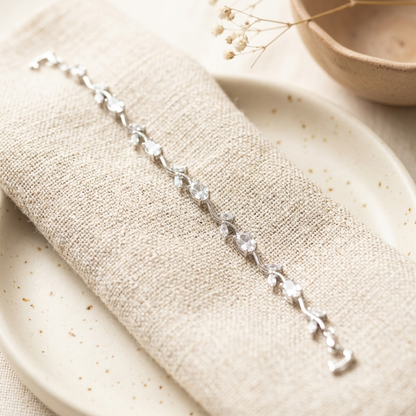 Silver White Stone Crystal Vine Leaf Bracelet on cream linen with ceramic plate