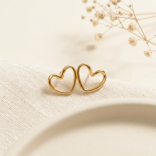 Gold Open Heart Stud Earrings held in hand close up