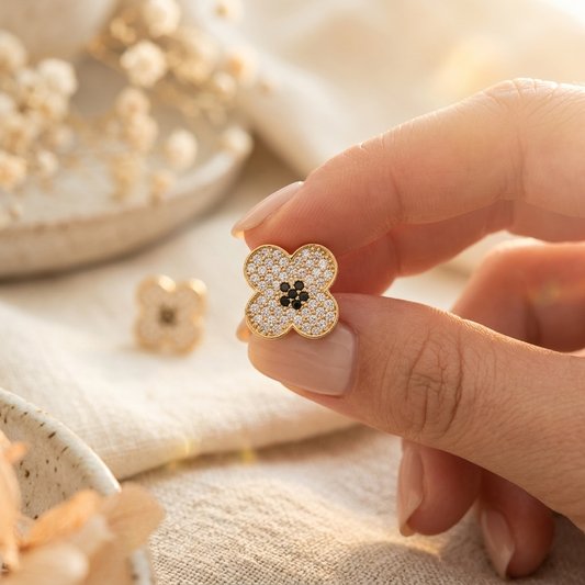 Gold Pave Four-Petal Flower Stud Earring held in hand close up